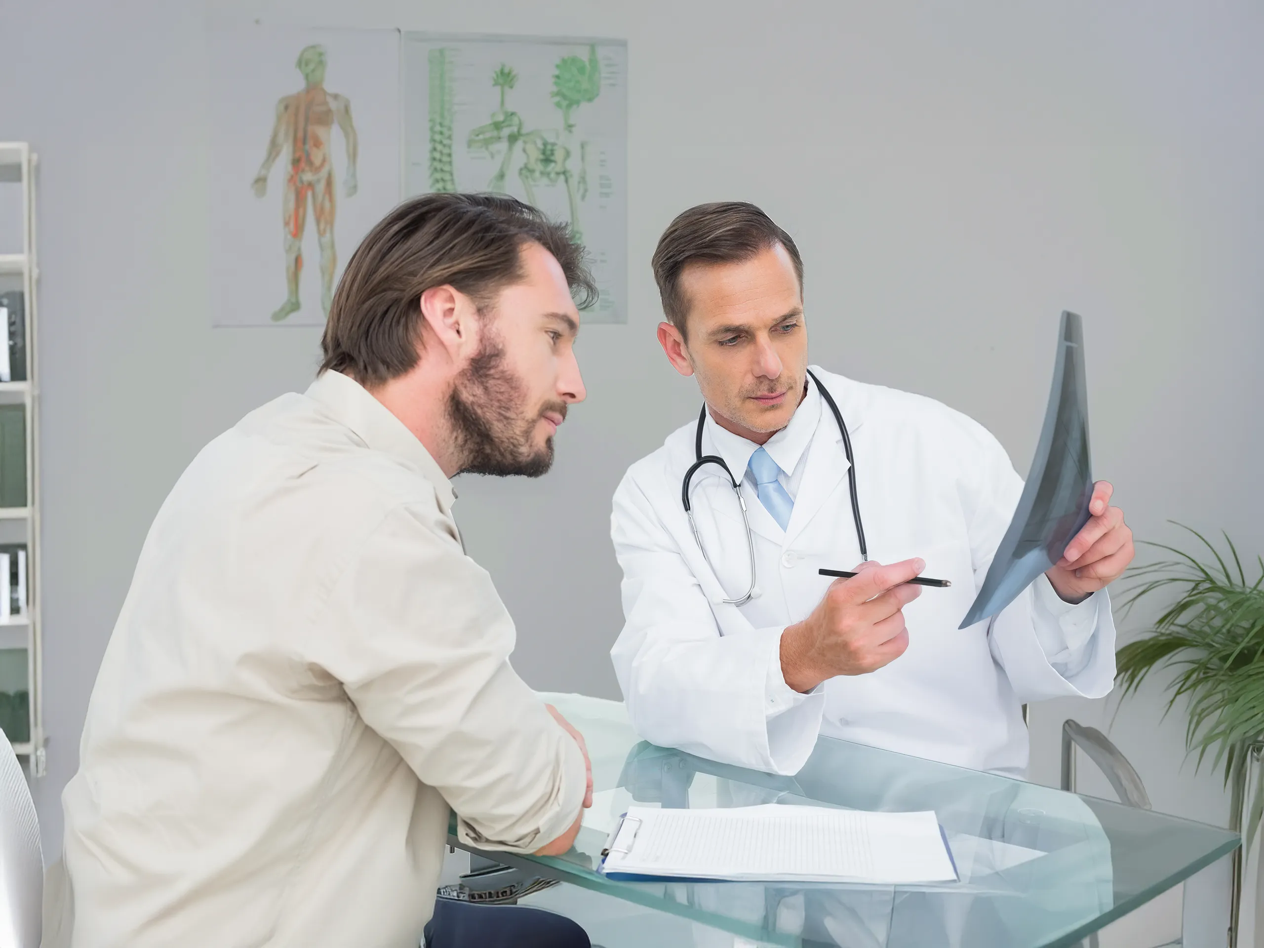 Arzt erklärt Röntgenbild einem männlichen Patienten