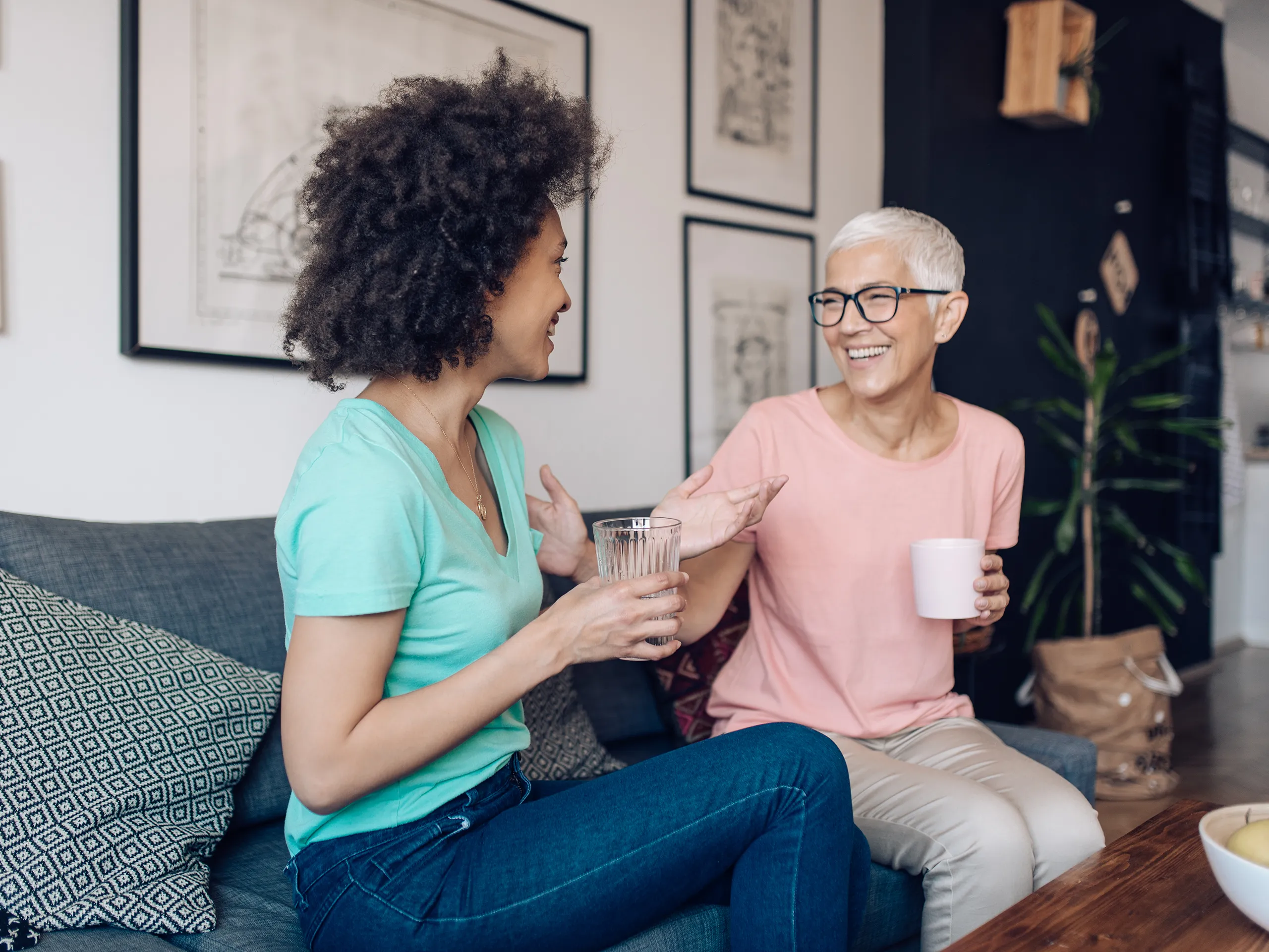 Zwei Frauen unterhalten sich freundlich auf einer Couch