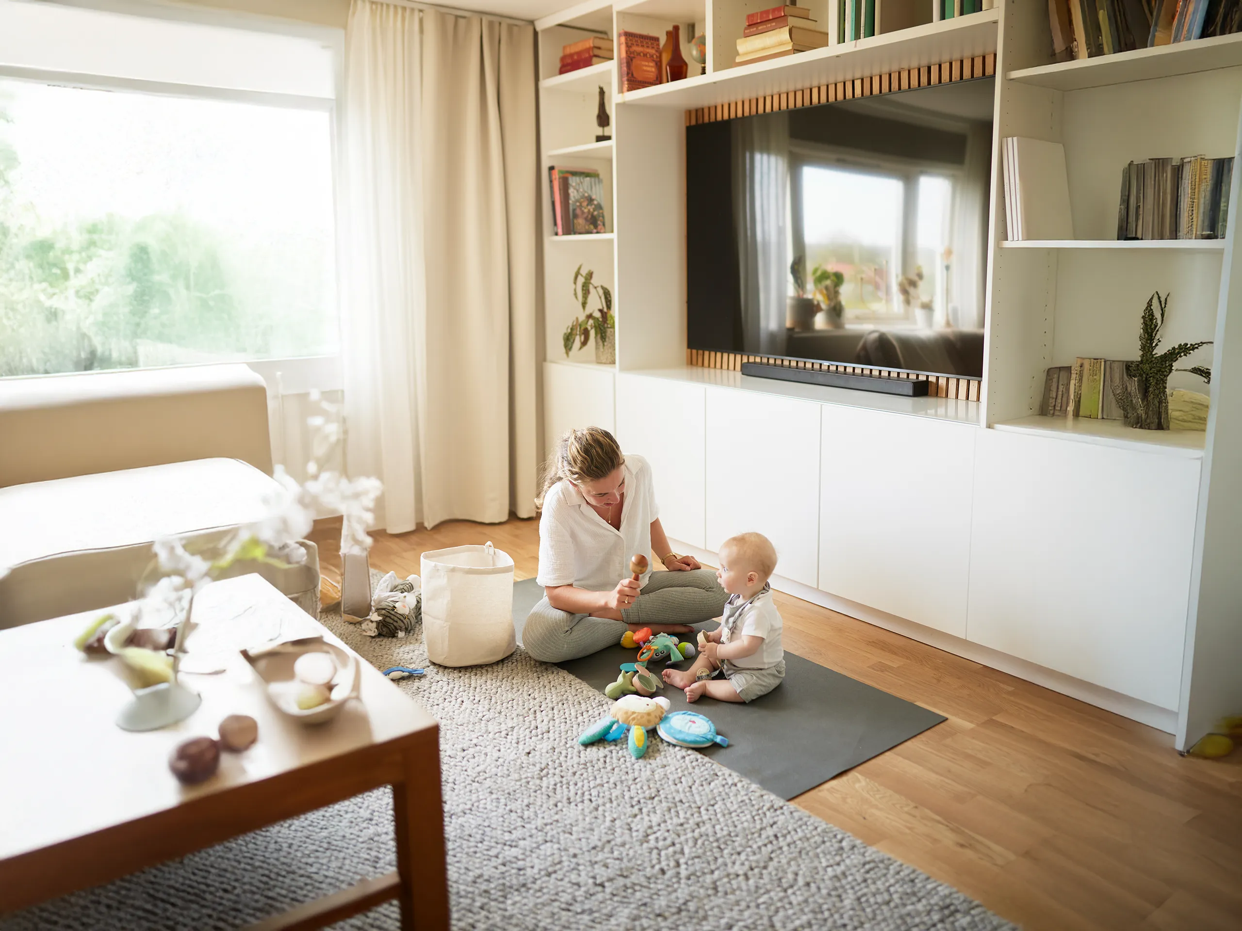 Mutter spielt mit Baby auf Spielmatte im Wohnzimmer