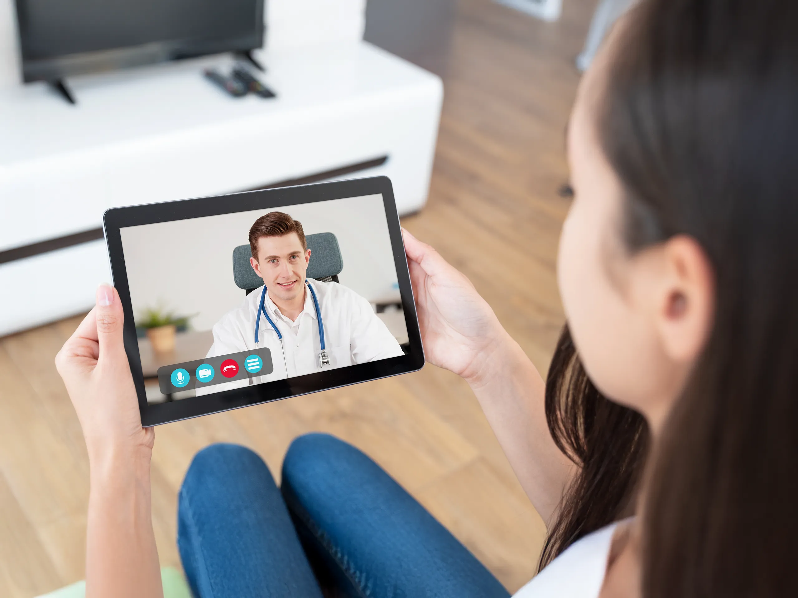 Frau im Videoanruf mit Arzt auf Tablet