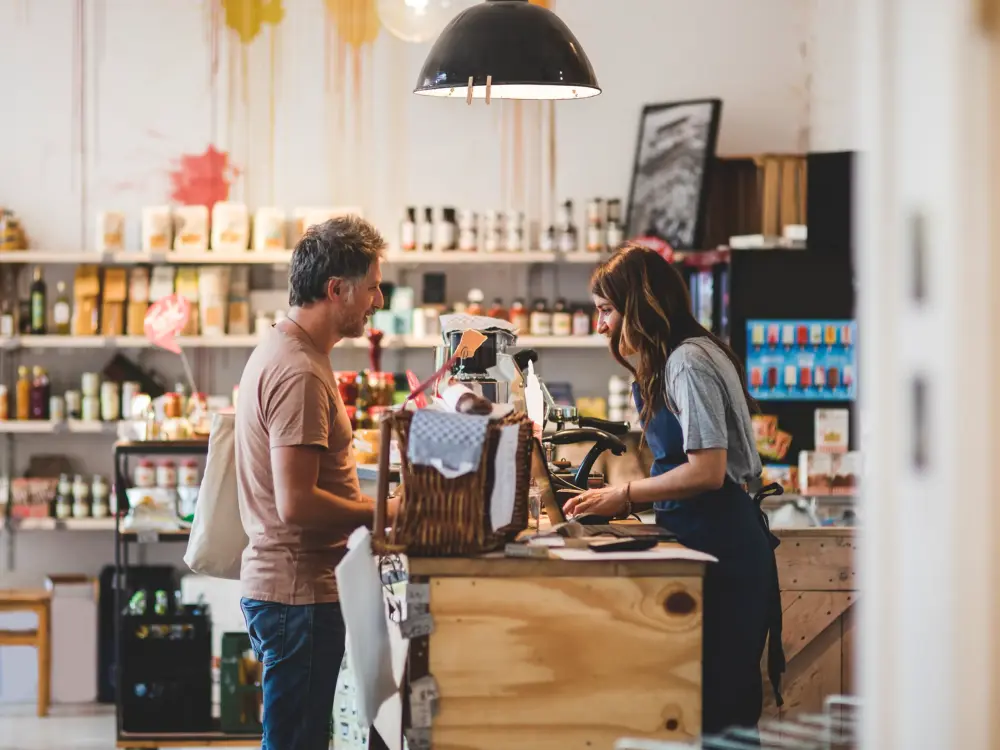 Mann und Frau unterhalten sich an der Kasse in einem Laden