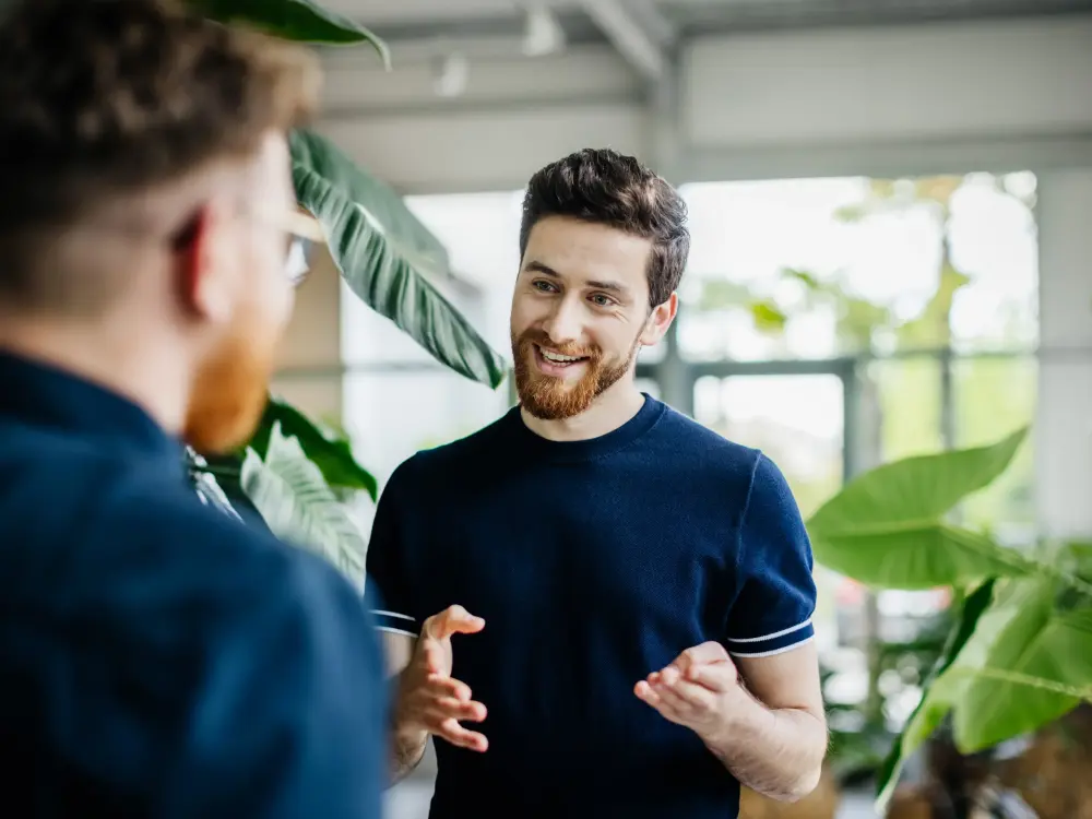 Mann im Gespräch mit einer anderen Person in einem modernen Büro